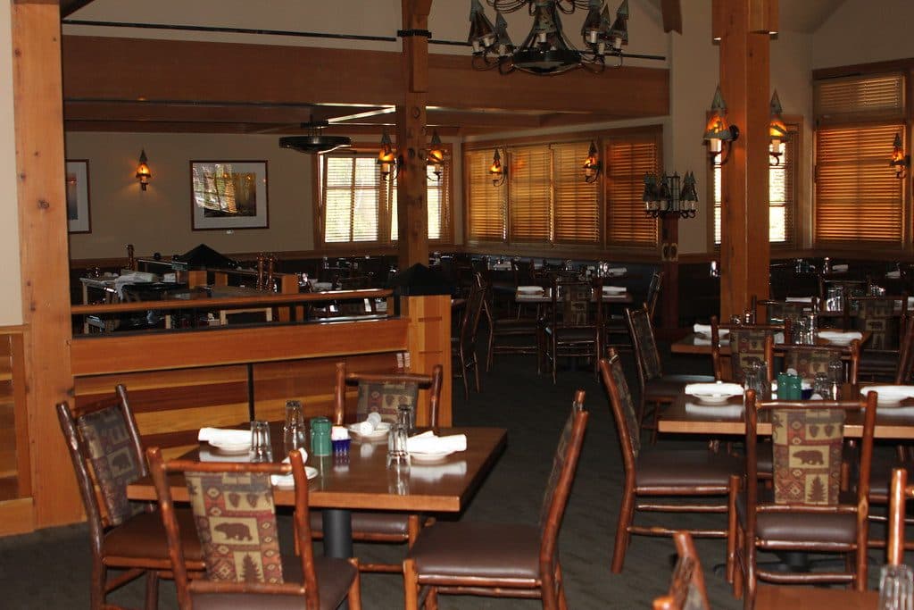 Sala acolhedora da Taberna dos Mercadores com mesas de madeira na Ribeira
